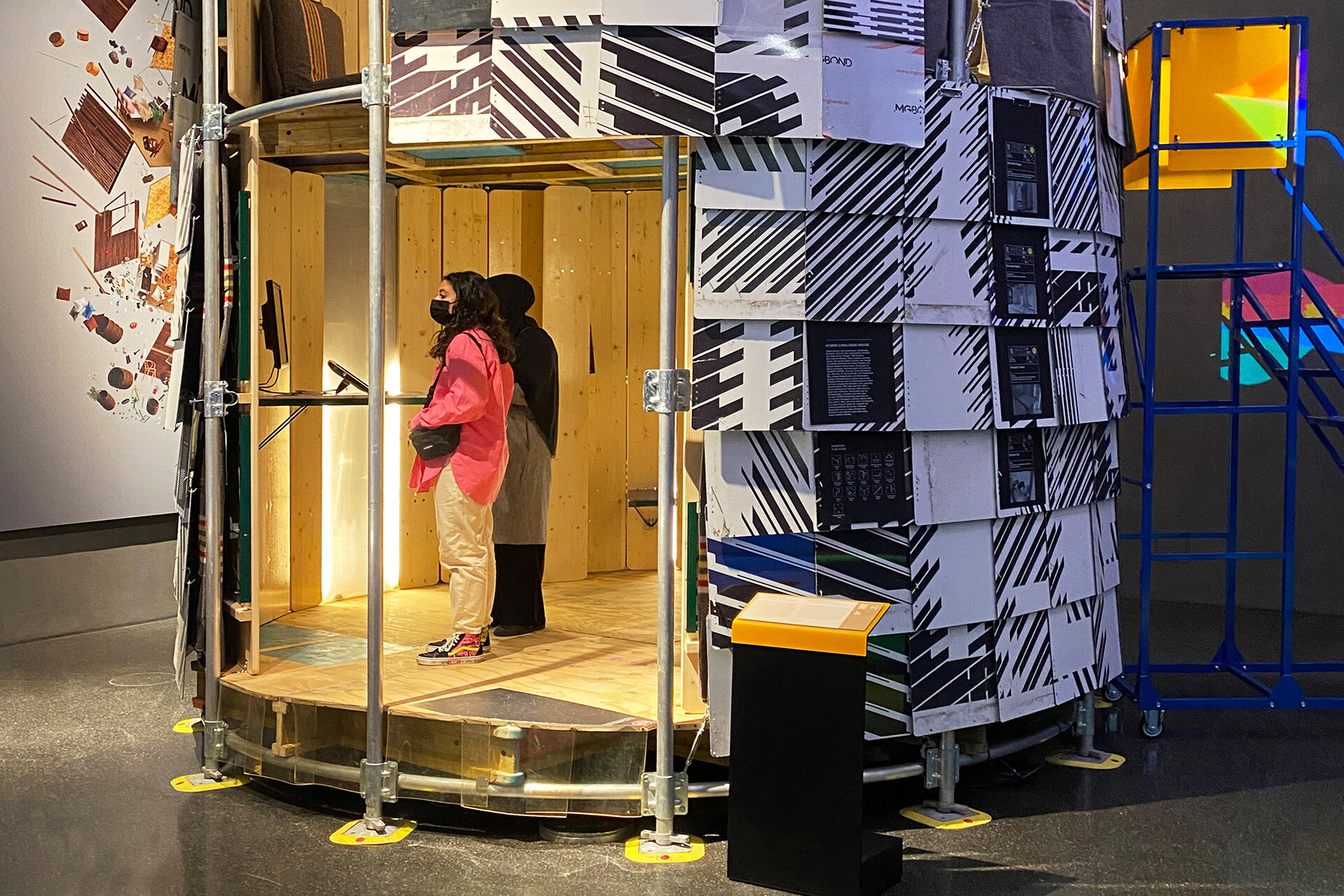 Rundes, selbstgebautes Haus aus Stangen, Bierbänken und Klemmbrettern mit Besucher:innen des Futuriums.