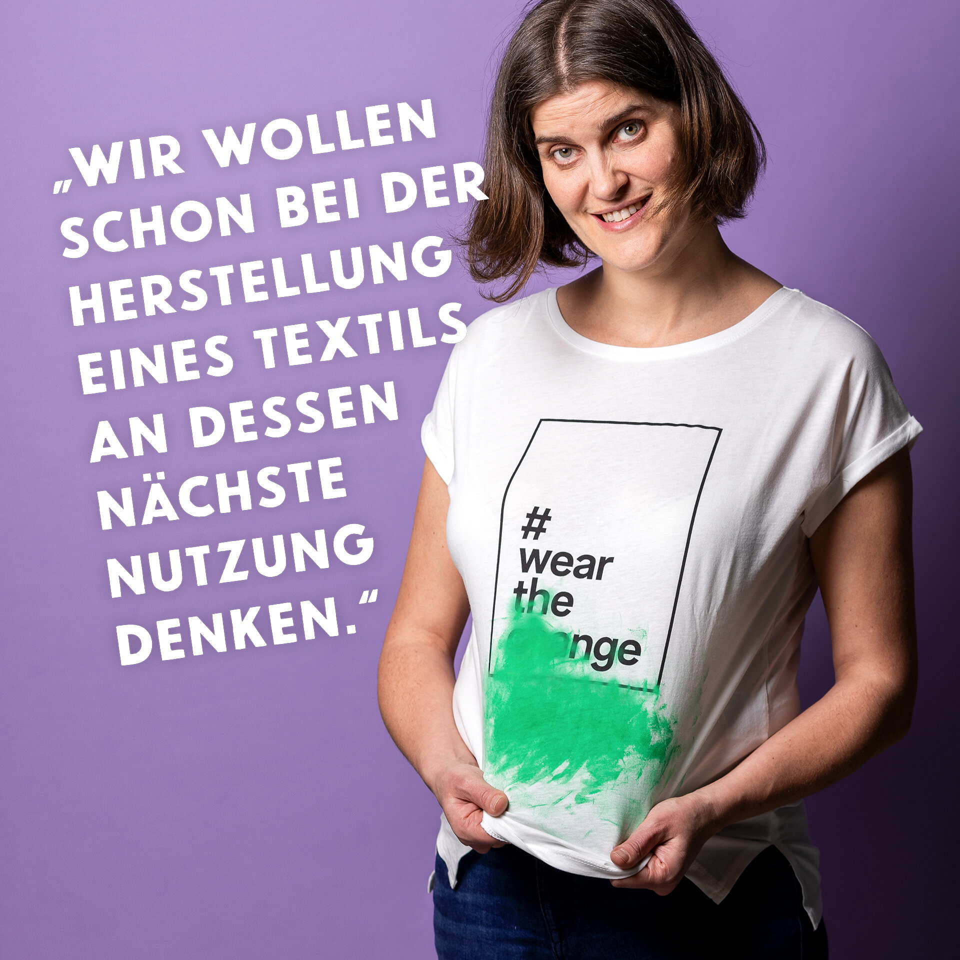 Frau stretcht ihr grün beflecktes T-Shirt. Zitat: „ Wir wollen schon bei der Herstellung eines Textils an dessen nächste Nutzung denken.“
