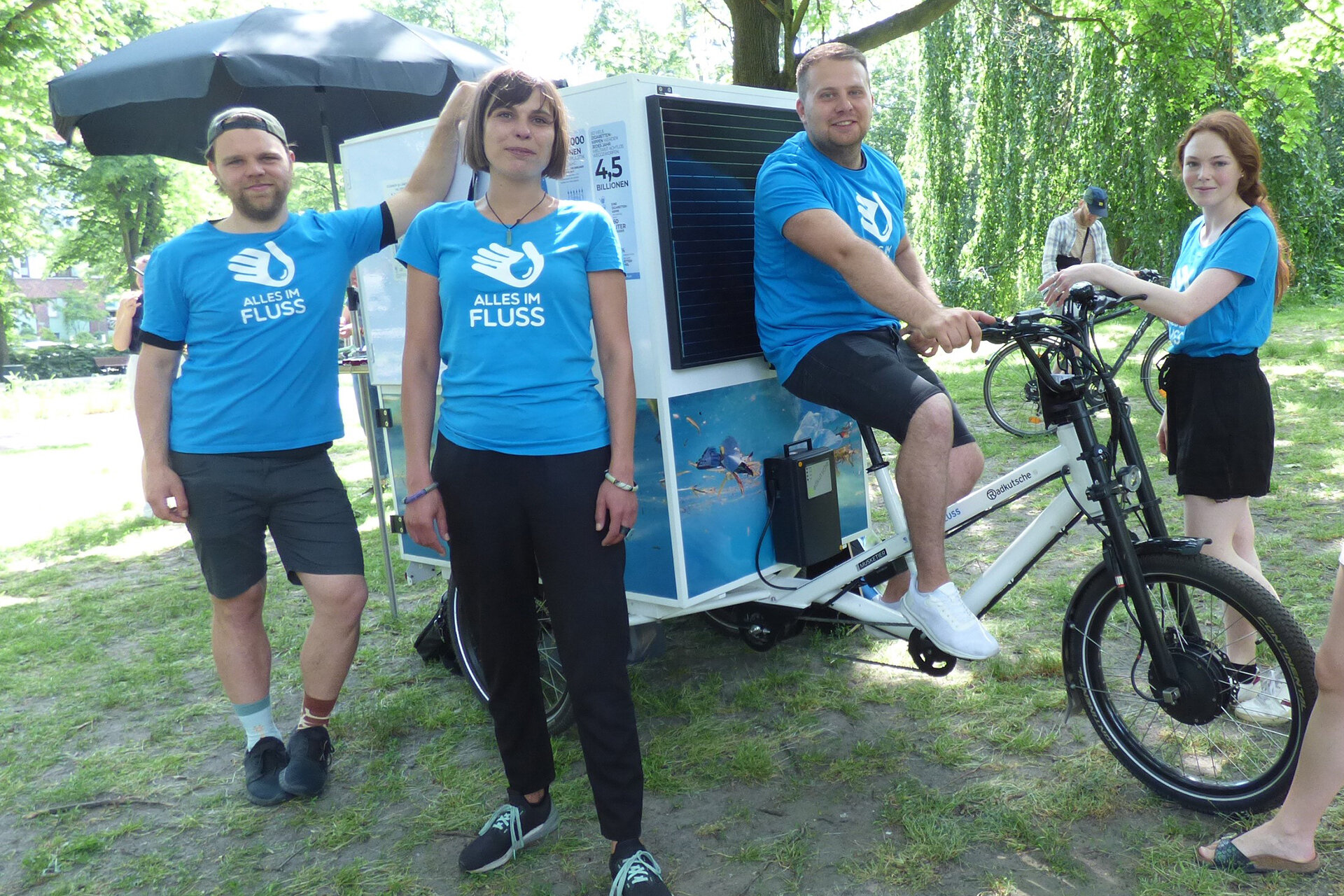 4 Menschen vom Verein Alles im Fluss vor ihrem Info-Mobil