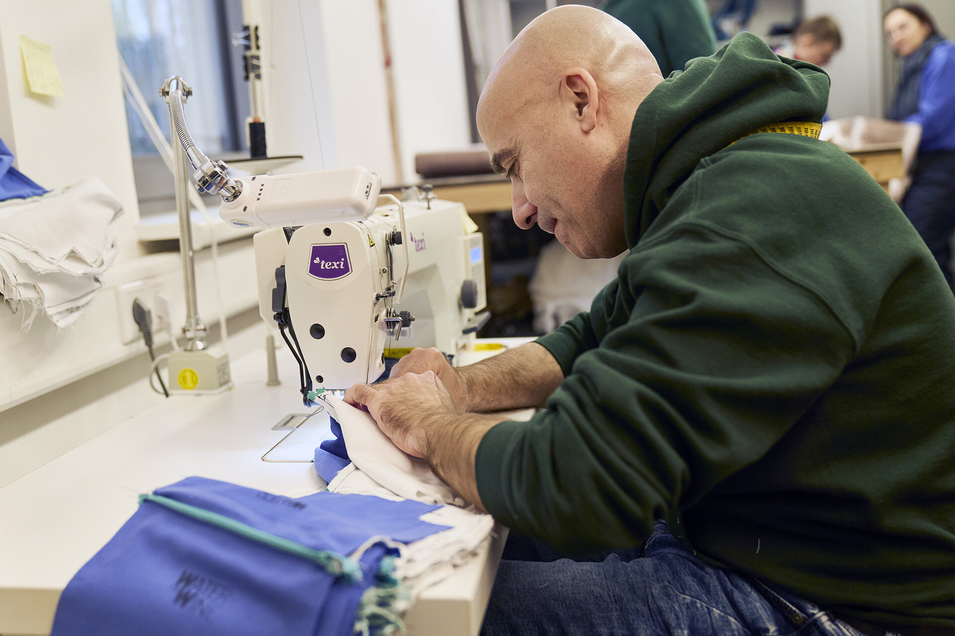 Inklusionsmanufaktur der Berliner Stadtmission, Bild eine Mannes der an einer Nähmaschine sitzt